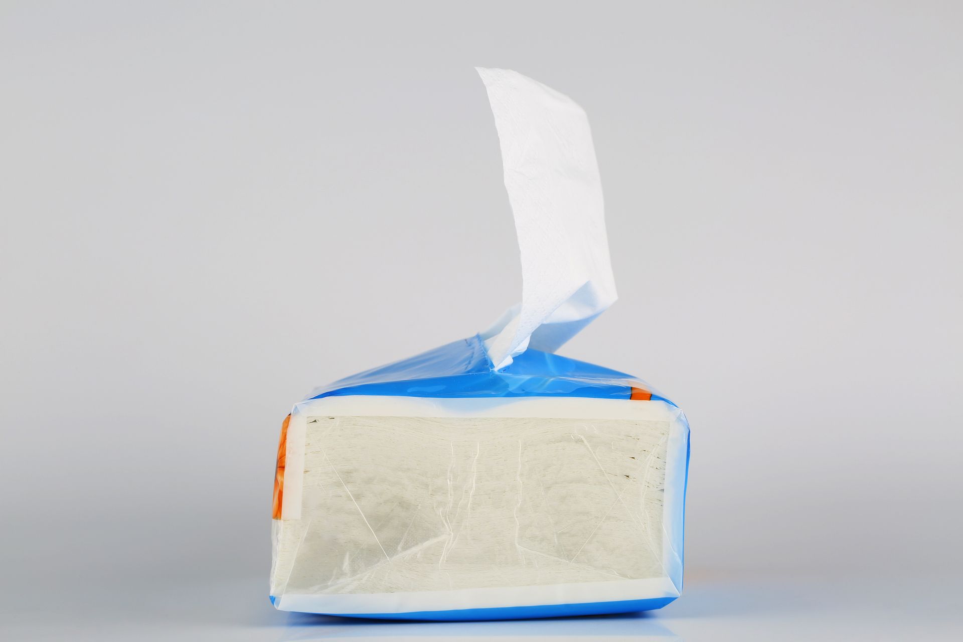 A blue and white bag of tissues is sitting on a table.