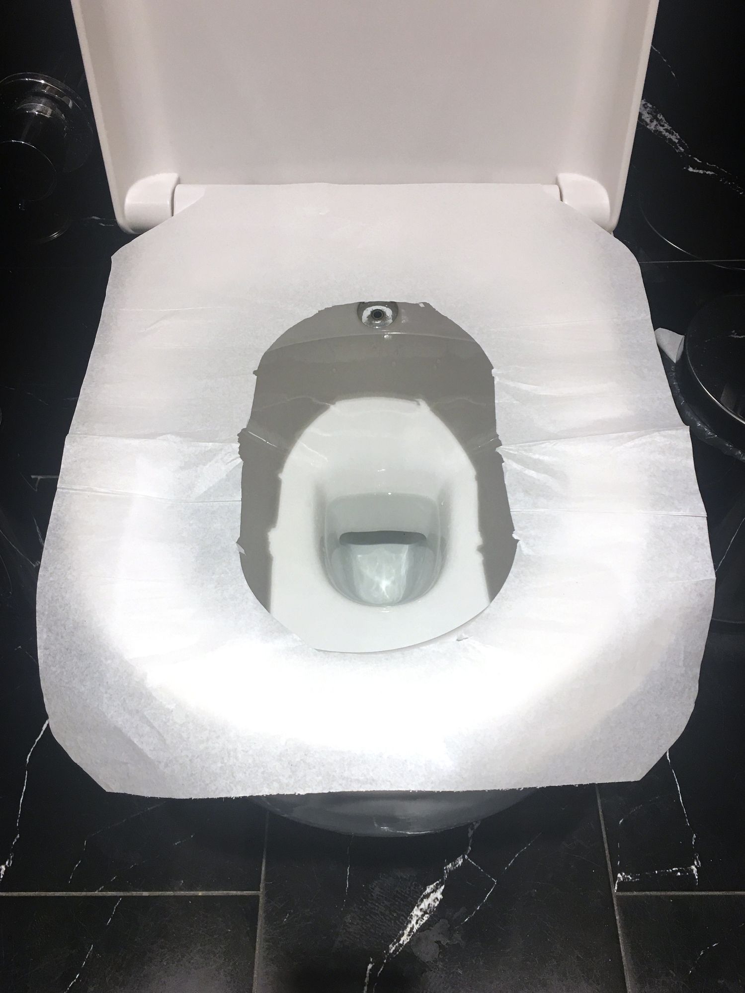 A toilet with a paper cover on the seat