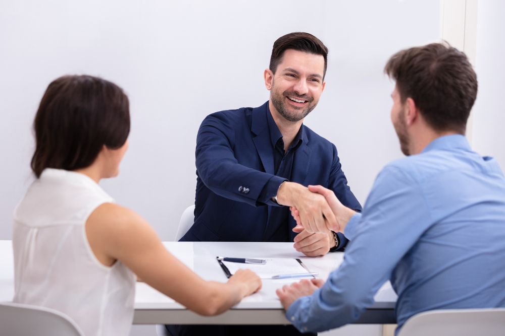 A Man and a Woman Are Shaking Hands With Their Lawyer — O'Reilly & Sochacki Lawyers in Kingscliff, NSW