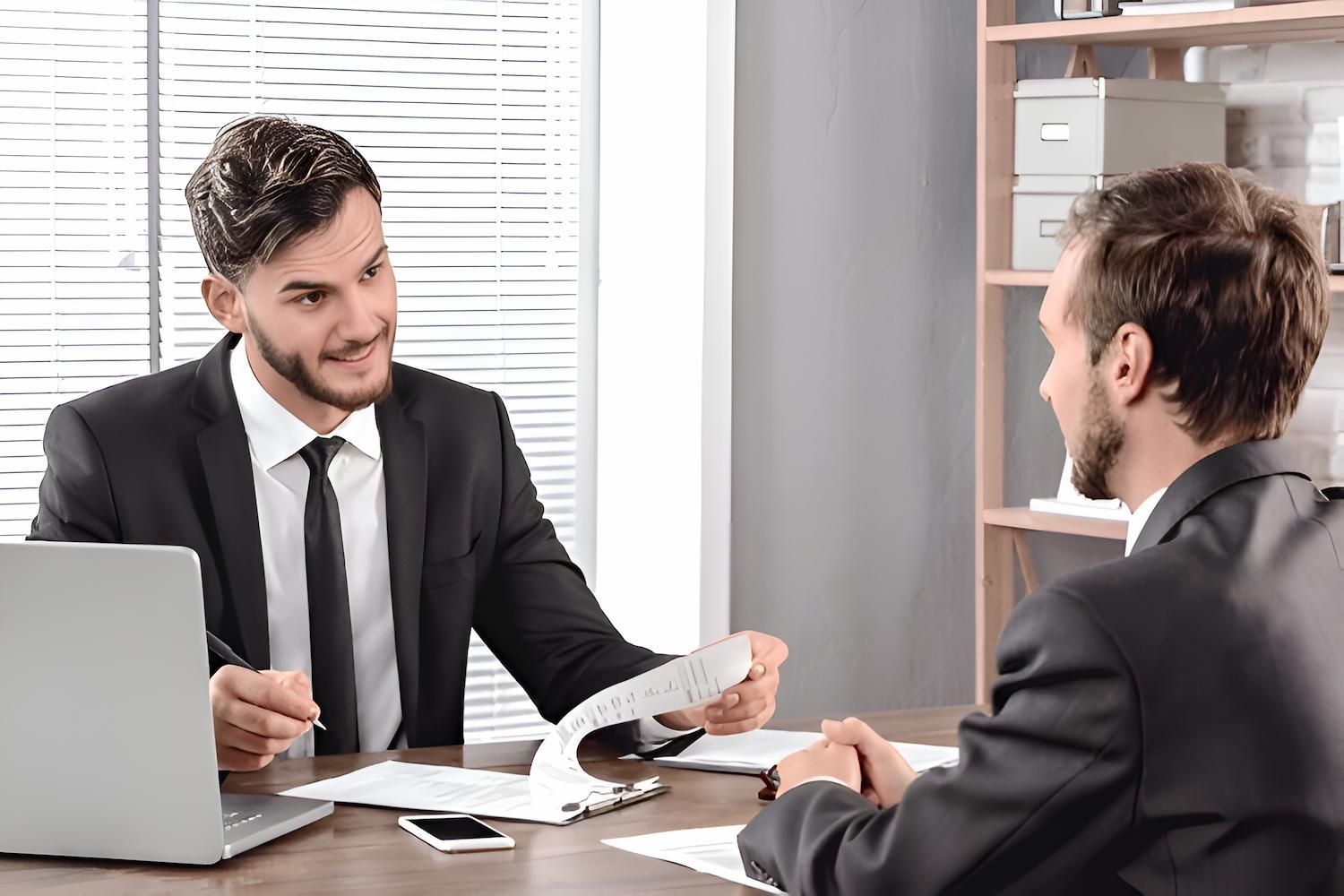 Two Men Are Sitting at a Table Having a Conversation — O'Reilly & Sochacki Lawyers in Murwillumbah, NSW