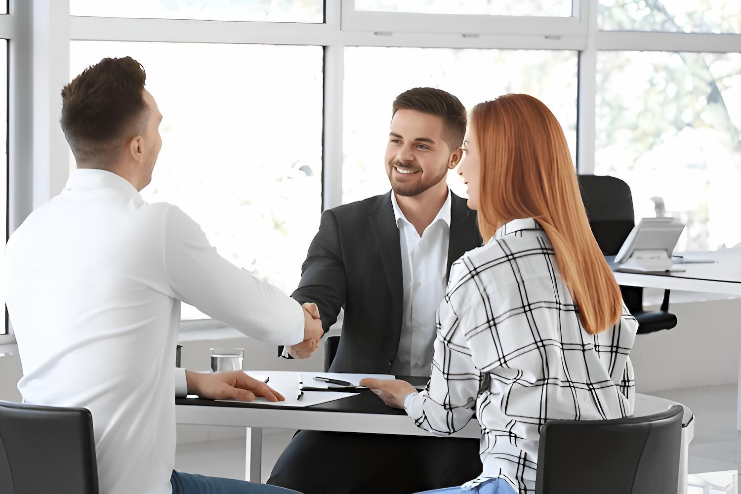 A Man and a Woman Are Shaking Hands While Sitting at a Table — O'Reilly & Sochacki Lawyers in Kingscliff, NSW