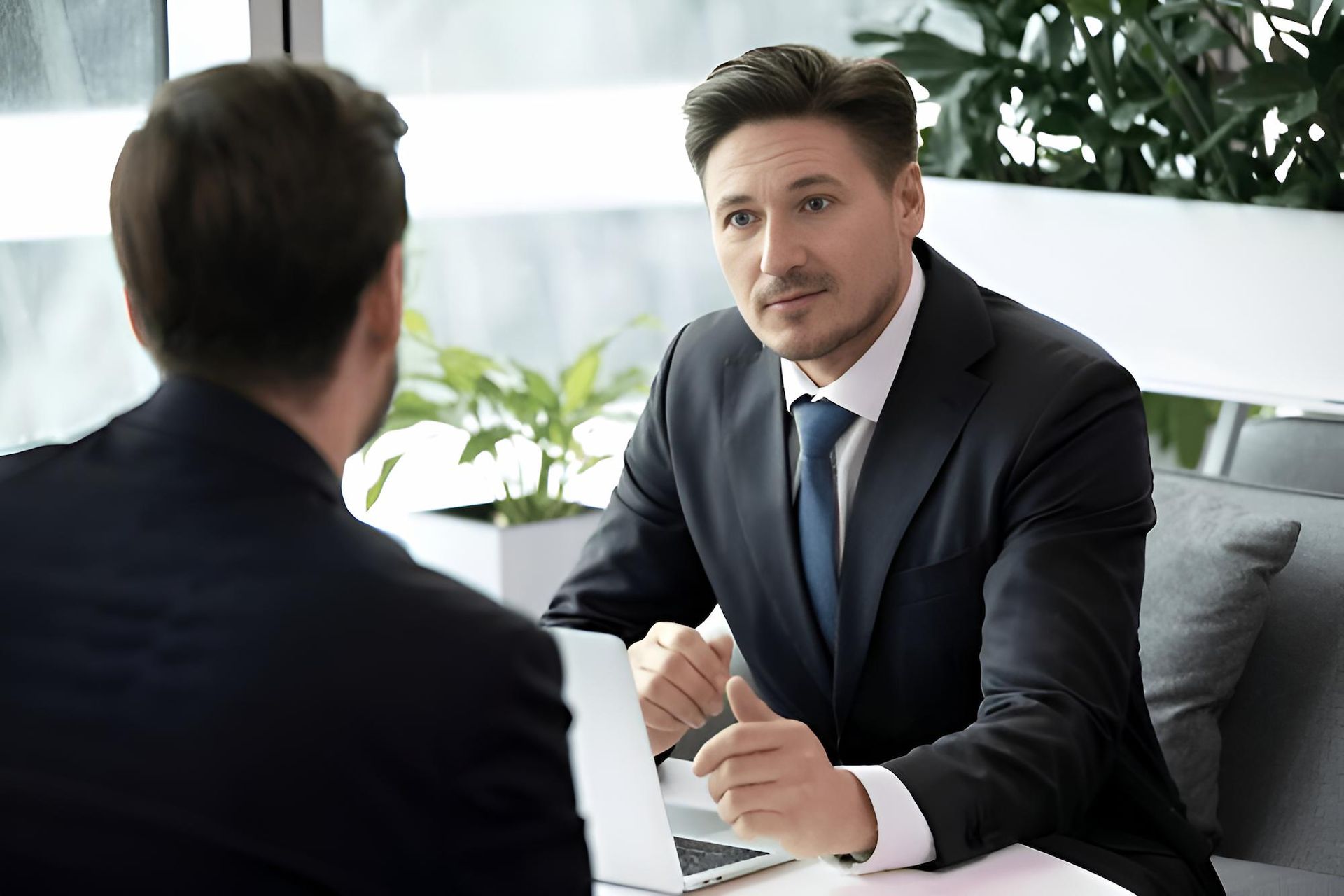 Two Men in Suits and Ties Are Sitting at a Table Having a Conversation — O'Reilly & Sochacki Lawyers in Murwillumbah, NSW