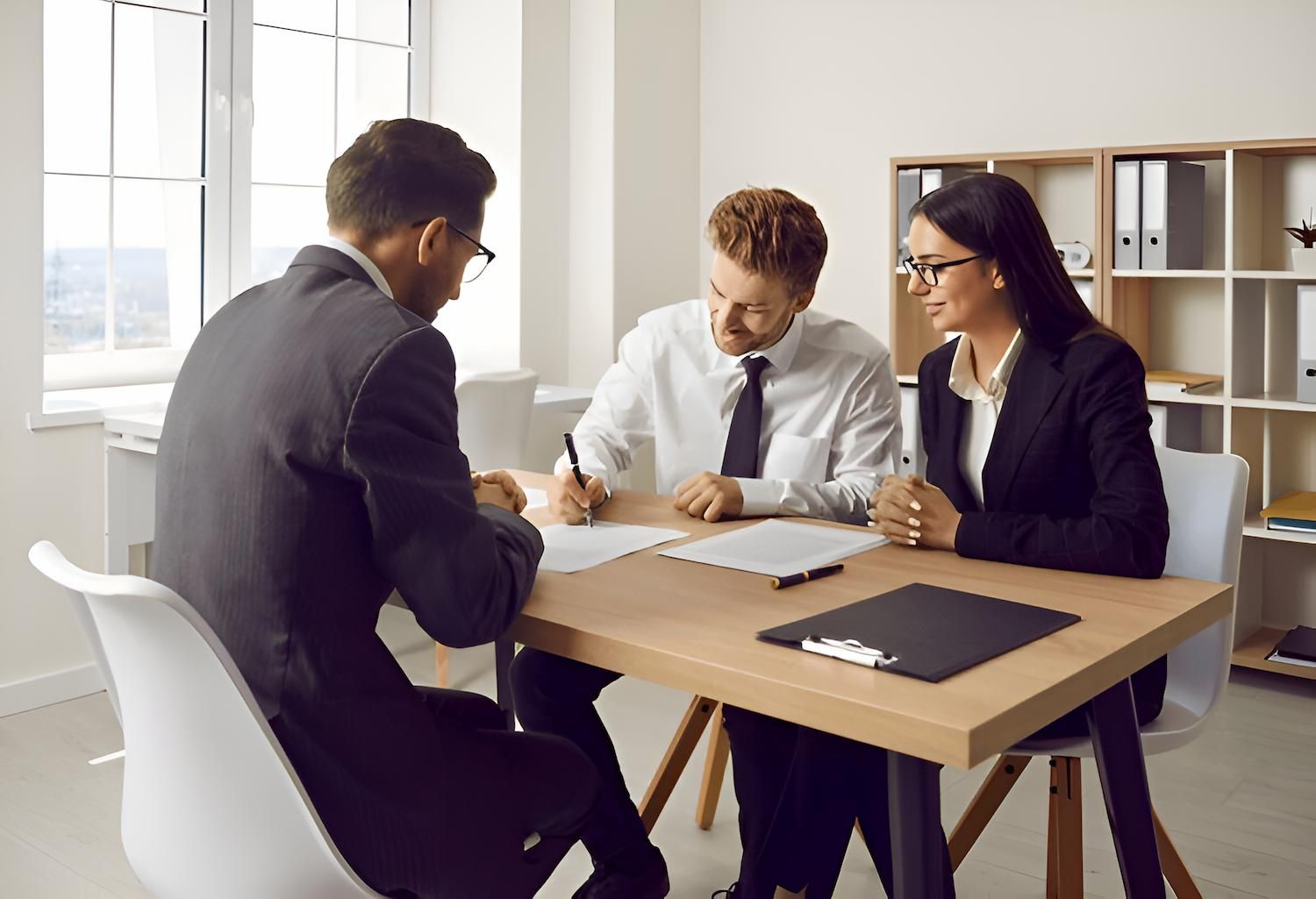 A Man and a Woman Are Sitting at a Table Signing a Document — O'Reilly & Sochacki Lawyers in Murwillumbah, NSW