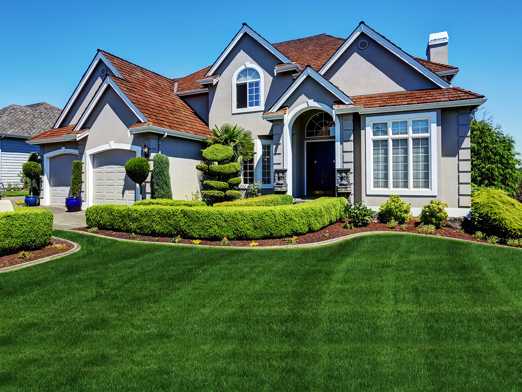 a large house with a lush green lawn in front of it .
