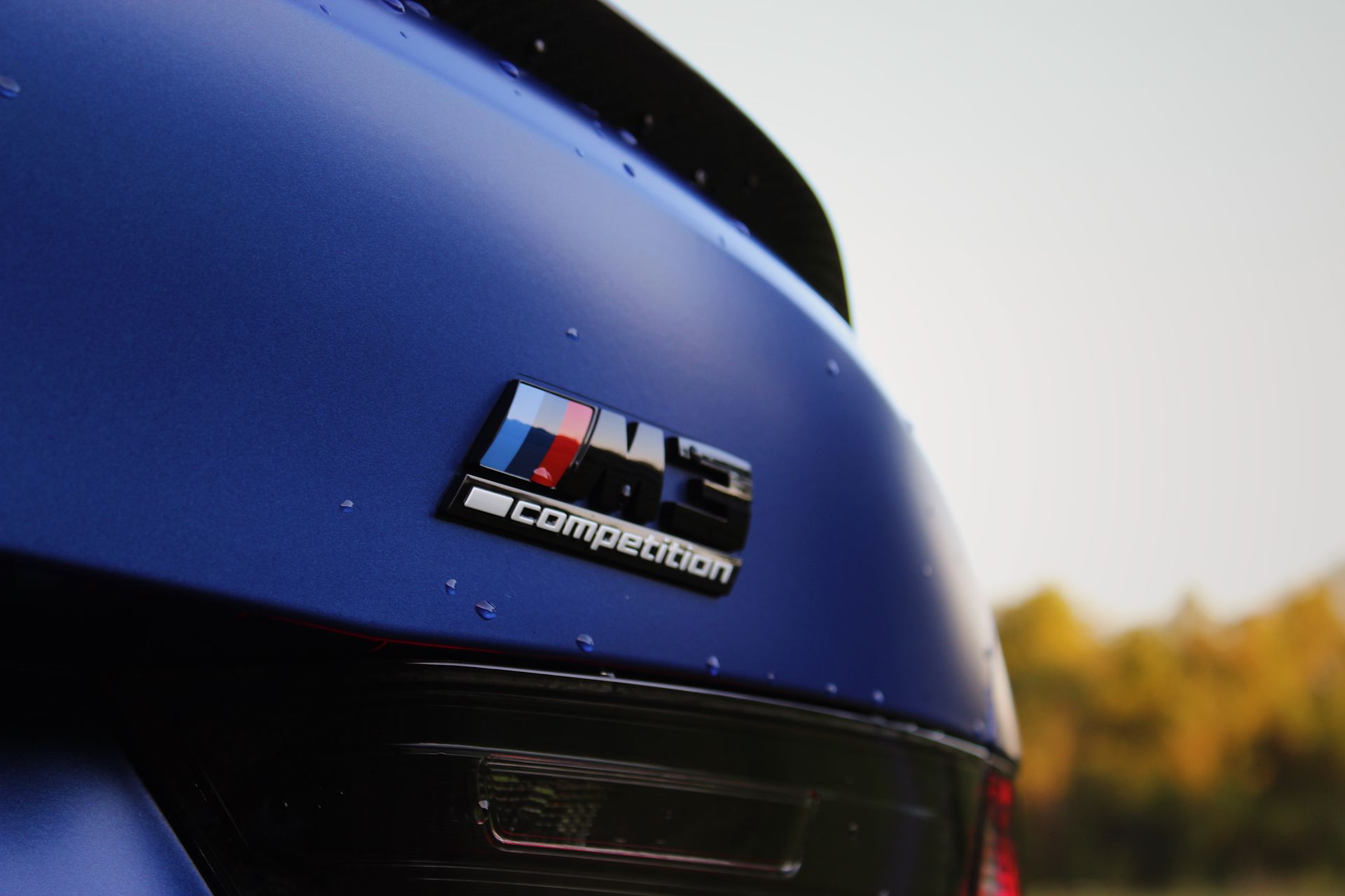 A close up of the back of a blue bmw m4 competition