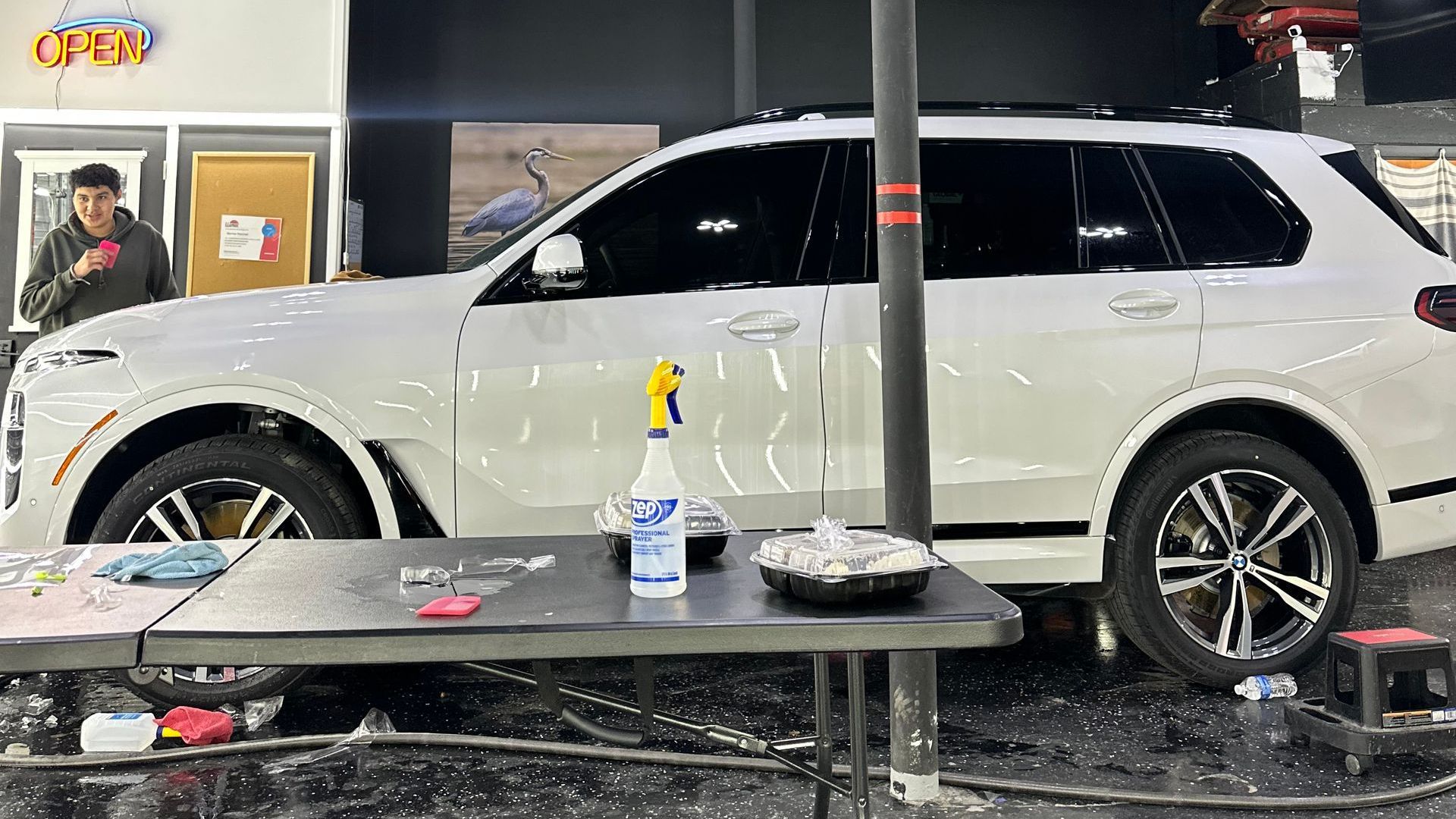 A white suv is parked next to a table in a car wash.