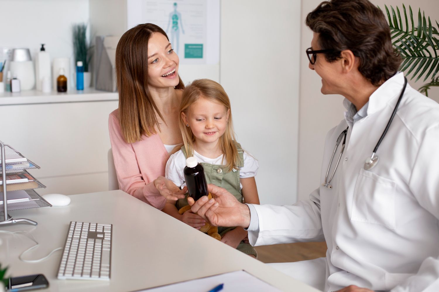 A doctor is giving a cell phone to a little girl.