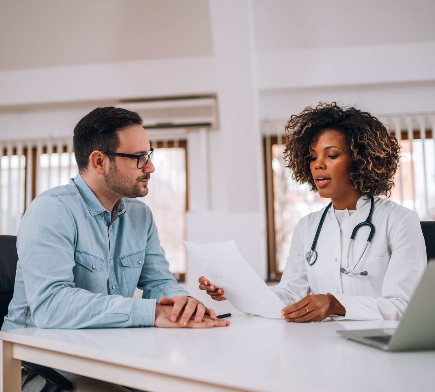 A woman is sitting at a table talking to another woman.