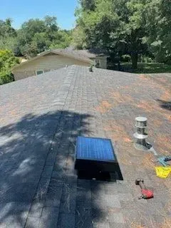 There is a solar panel on the roof of a house.