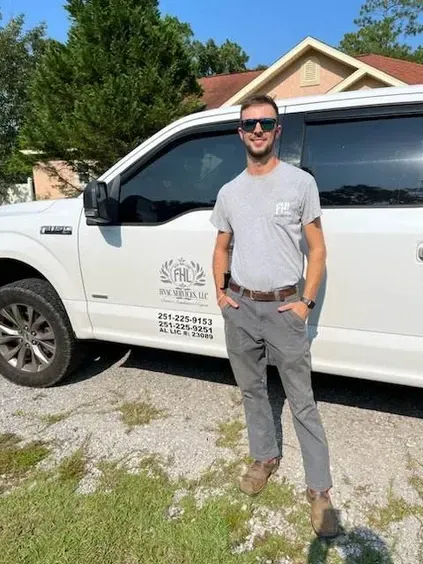 A man is standing in front of a white truck.