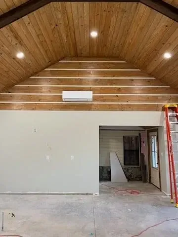 A room with a wooden ceiling and a ladder in it.