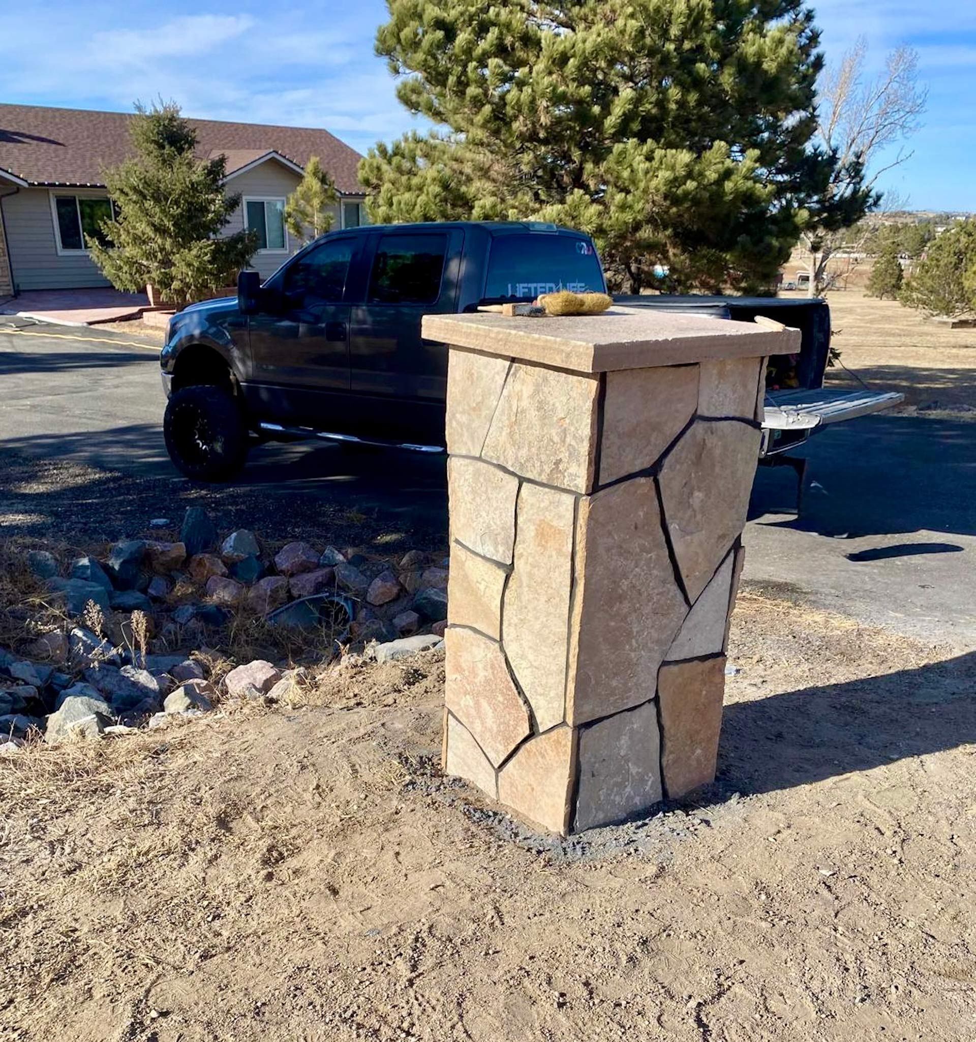 A truck is parked in front of a stone pillar