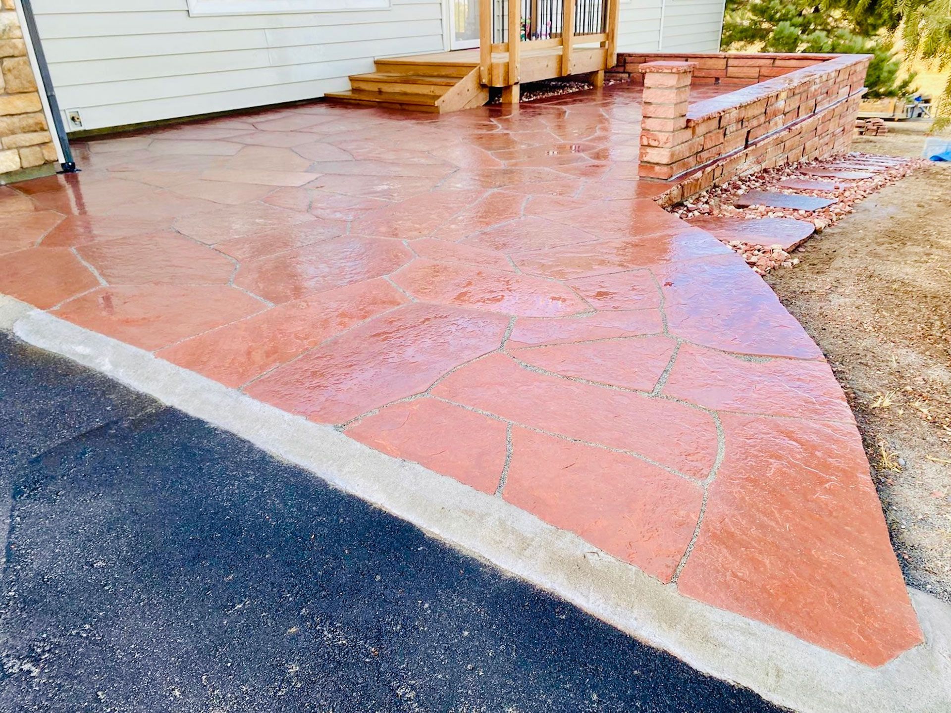 A red patio with a brick wall in front of a house.