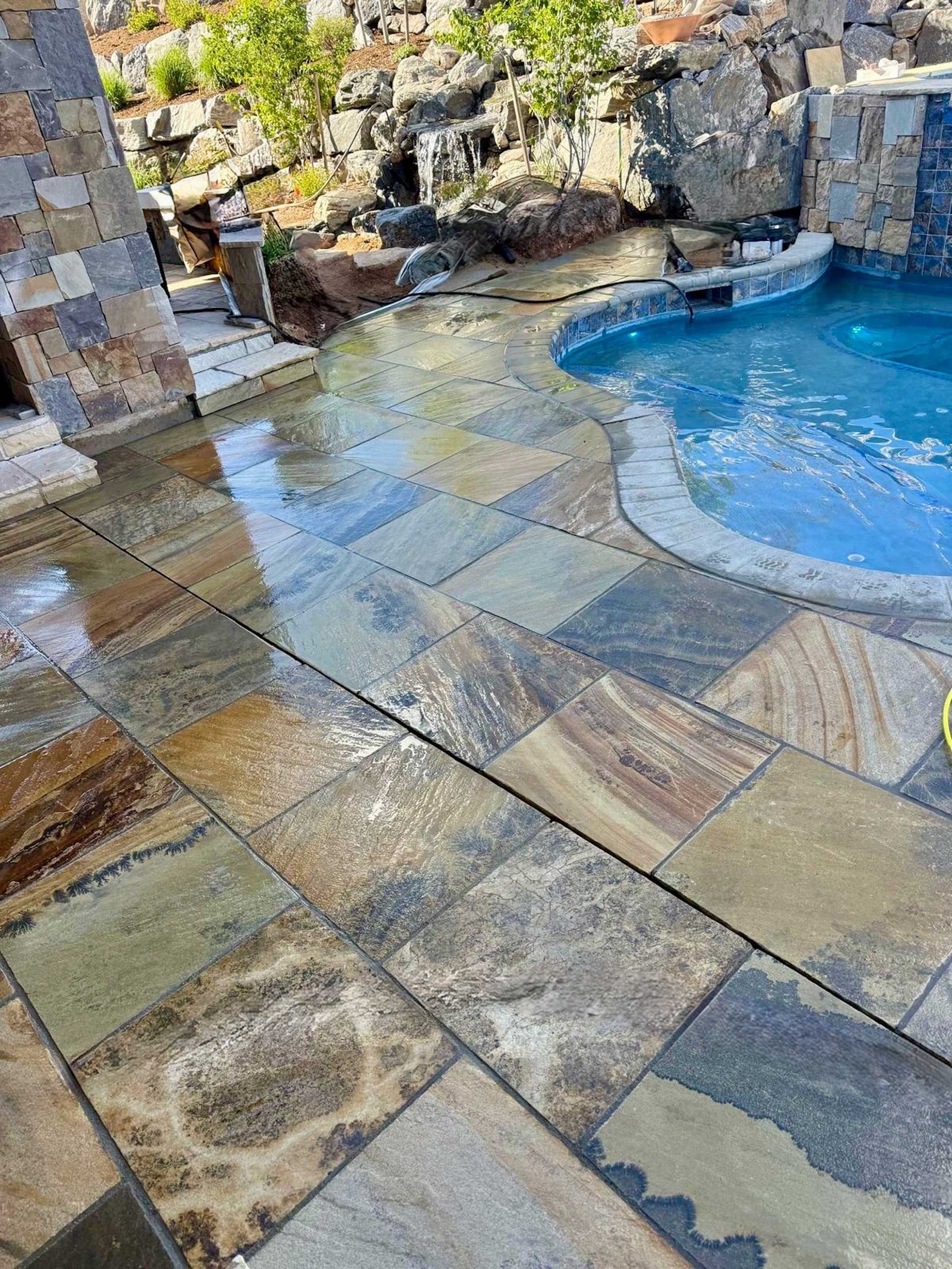 A patio with a swimming pool in the background.