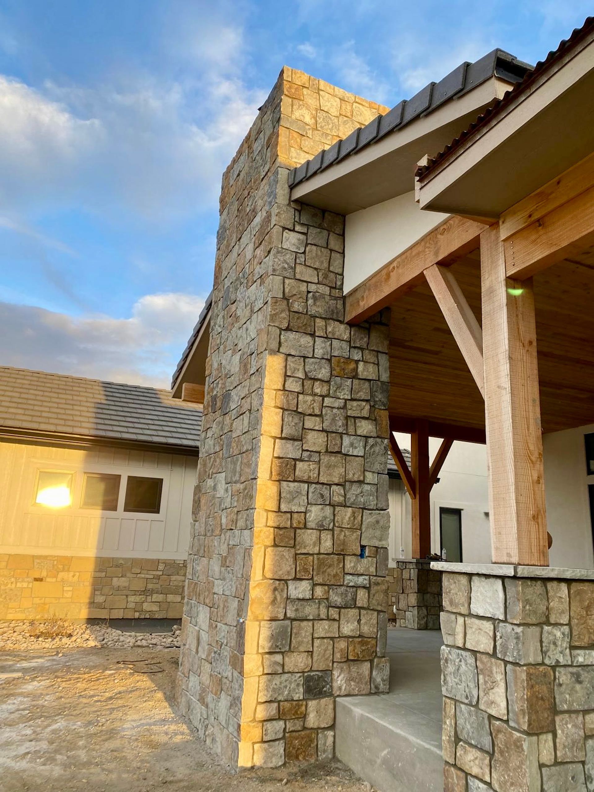 A house with a stone wall and a wooden porch