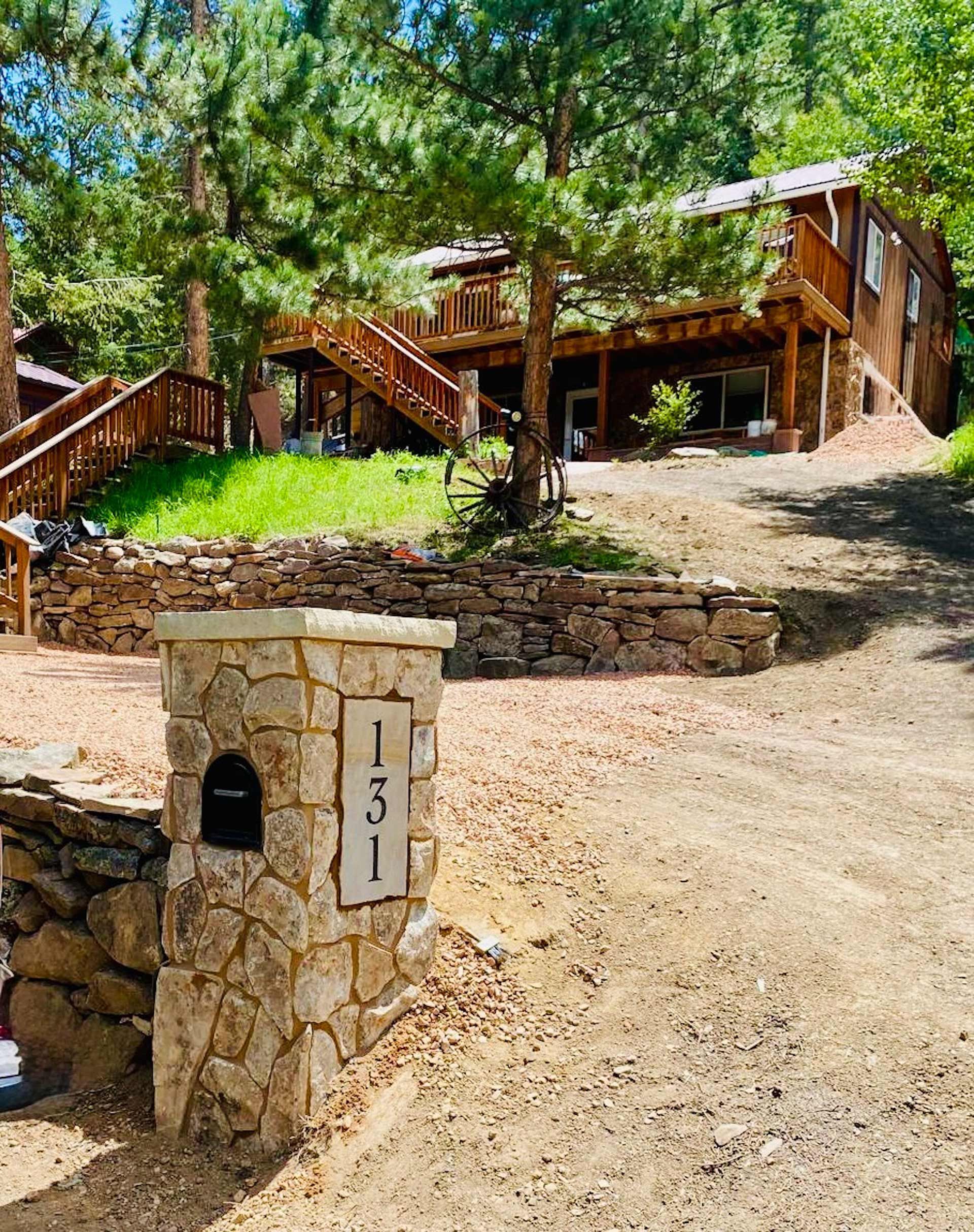 A large house with stairs and a mailbox in front of it.