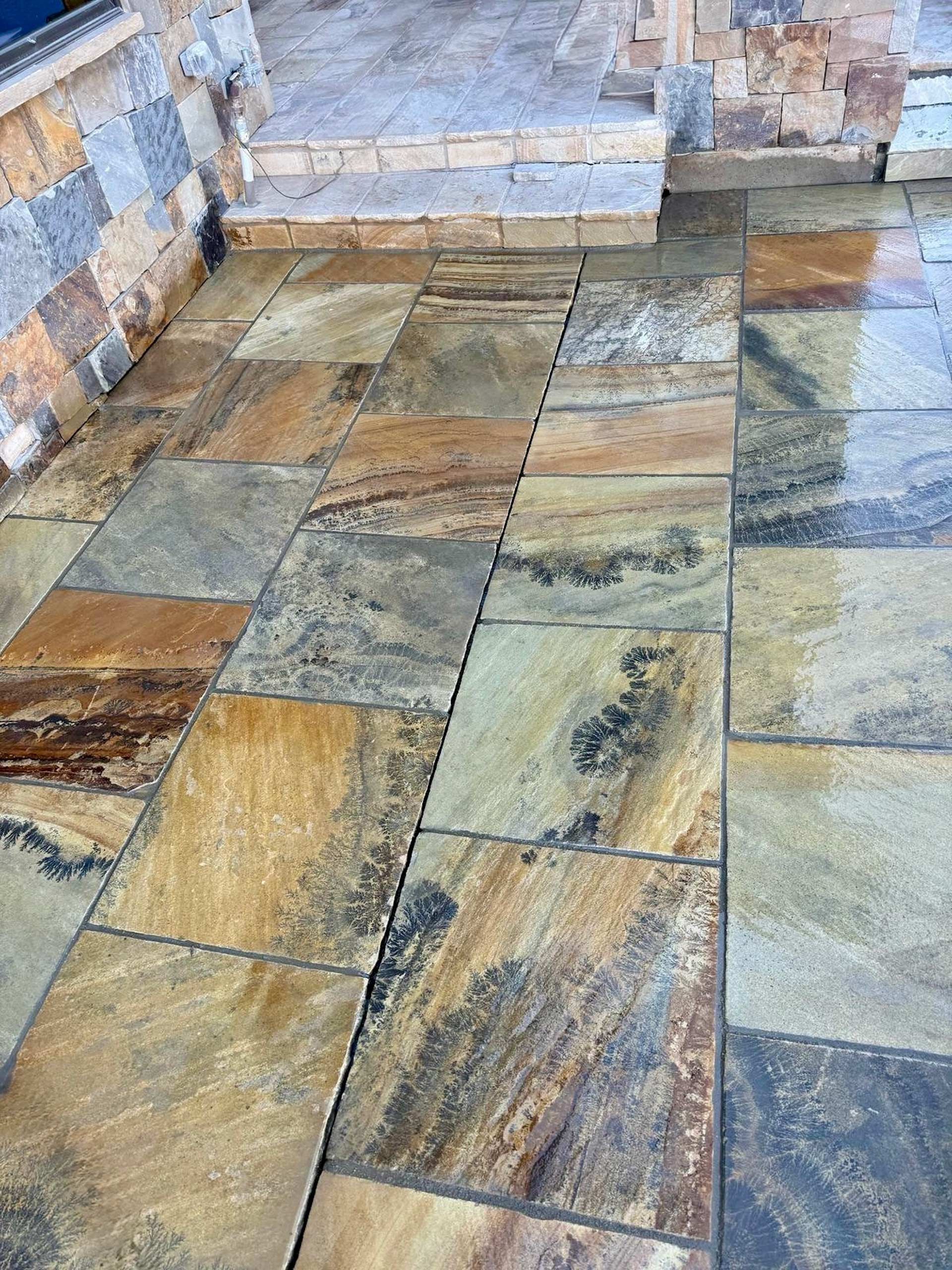 A close up of a tiled floor with a stone wall in the background.