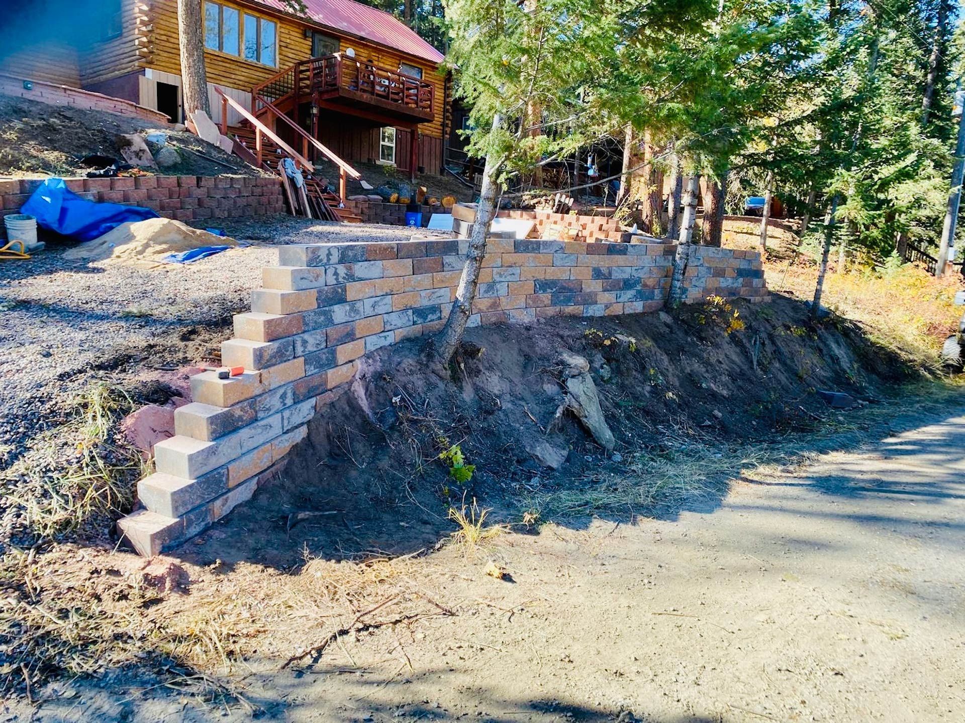 A brick wall is being built in front of a house.