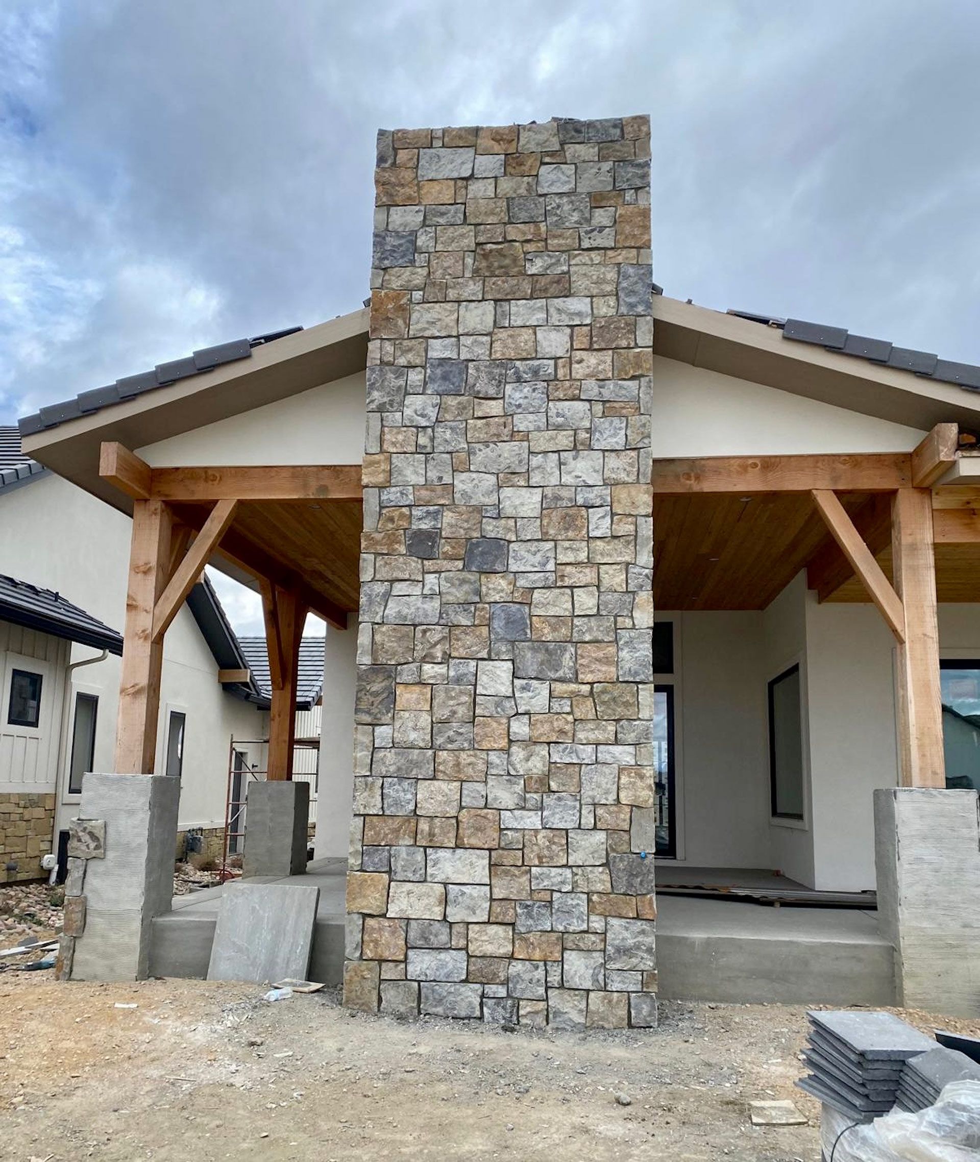 A house with a large stone chimney in front of it
