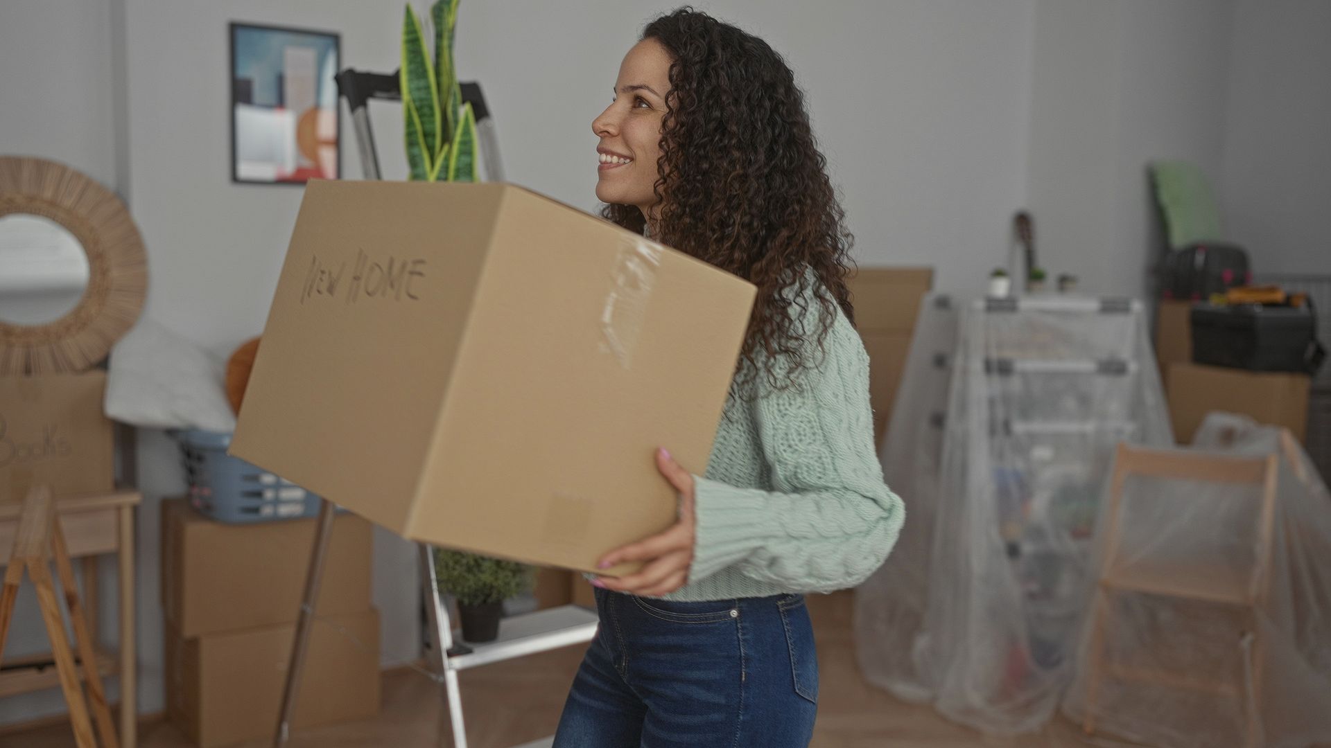 Woman carrying a cardboard box labeled