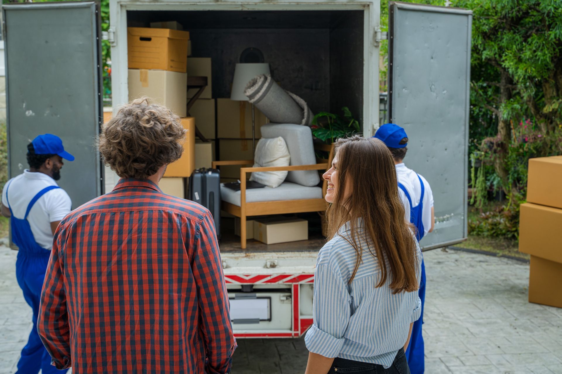 People and movers load a moving truck with boxes and furniture.