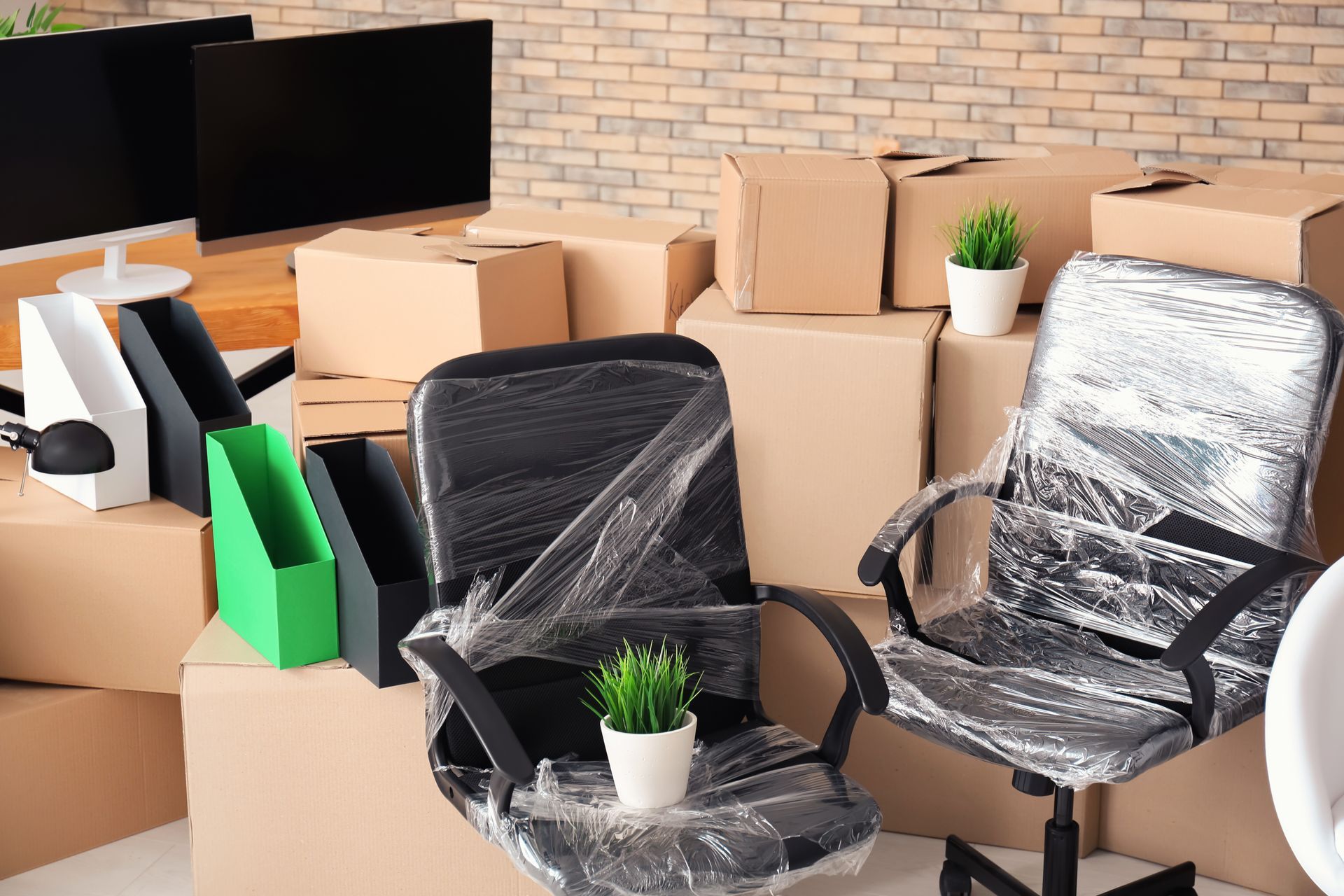 A number of office supplies and furniture are packed and ready to be moved.