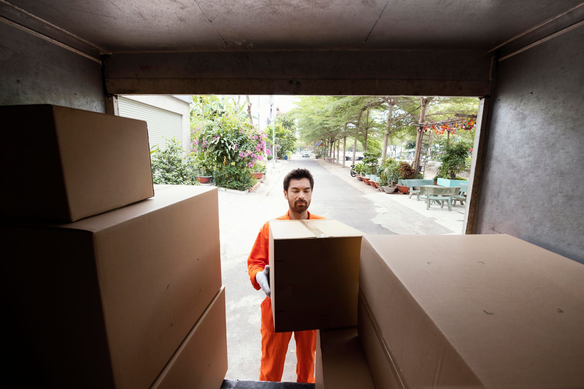 A man is carrying a box out of a truck.