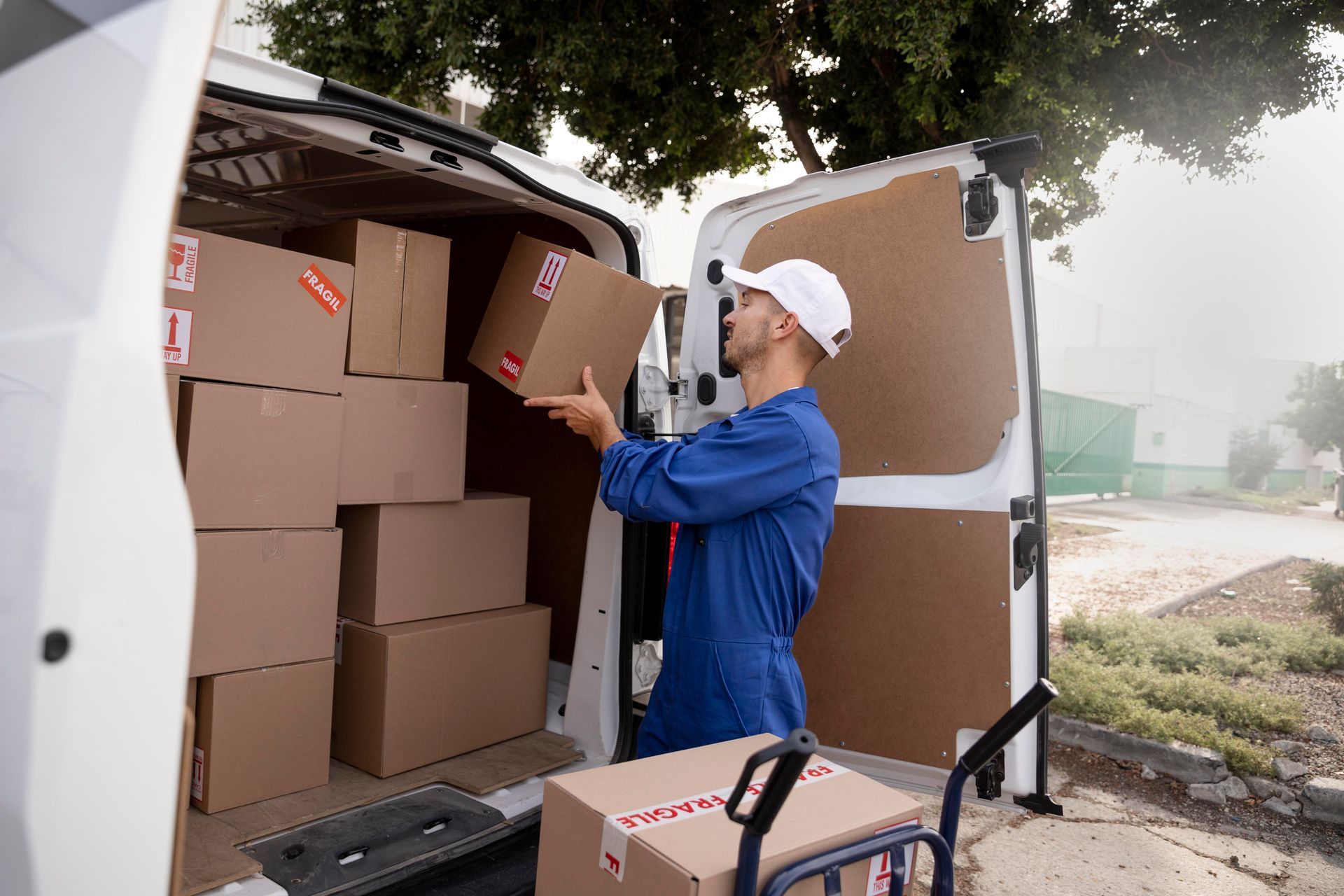 A delivery man is loading boxes into a van.