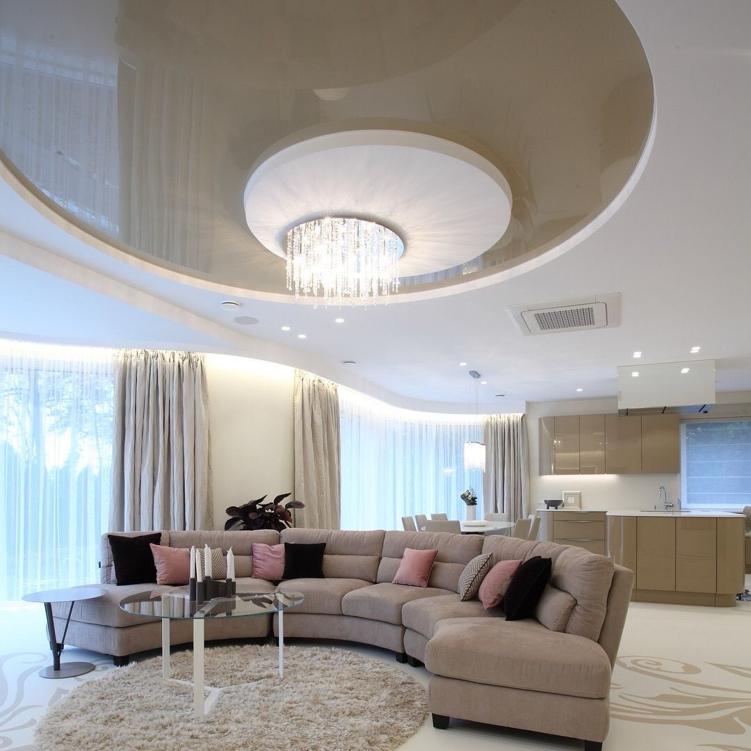 Elegant living room with curved sofa, chandelier, and beige-toned walls.