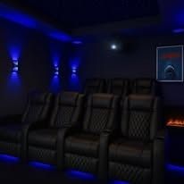A home theater with black leather seats and blue lights.