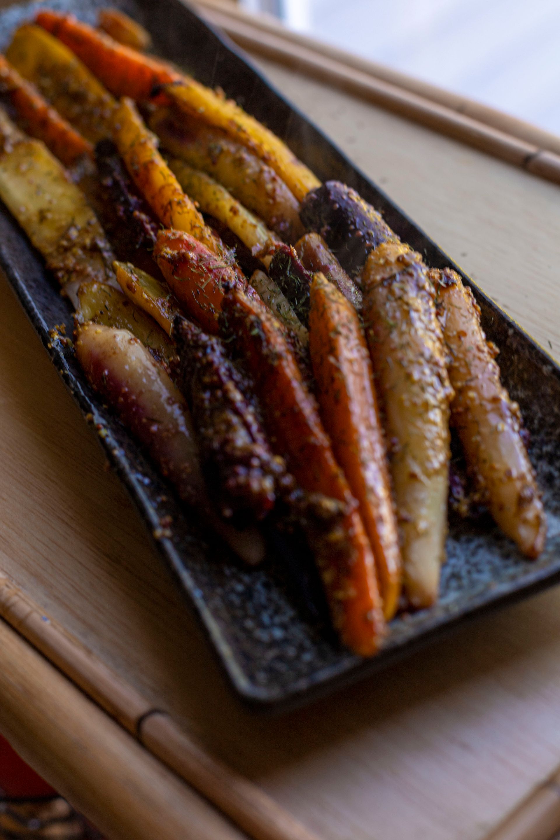 A close up of a plate of carrots on a table.