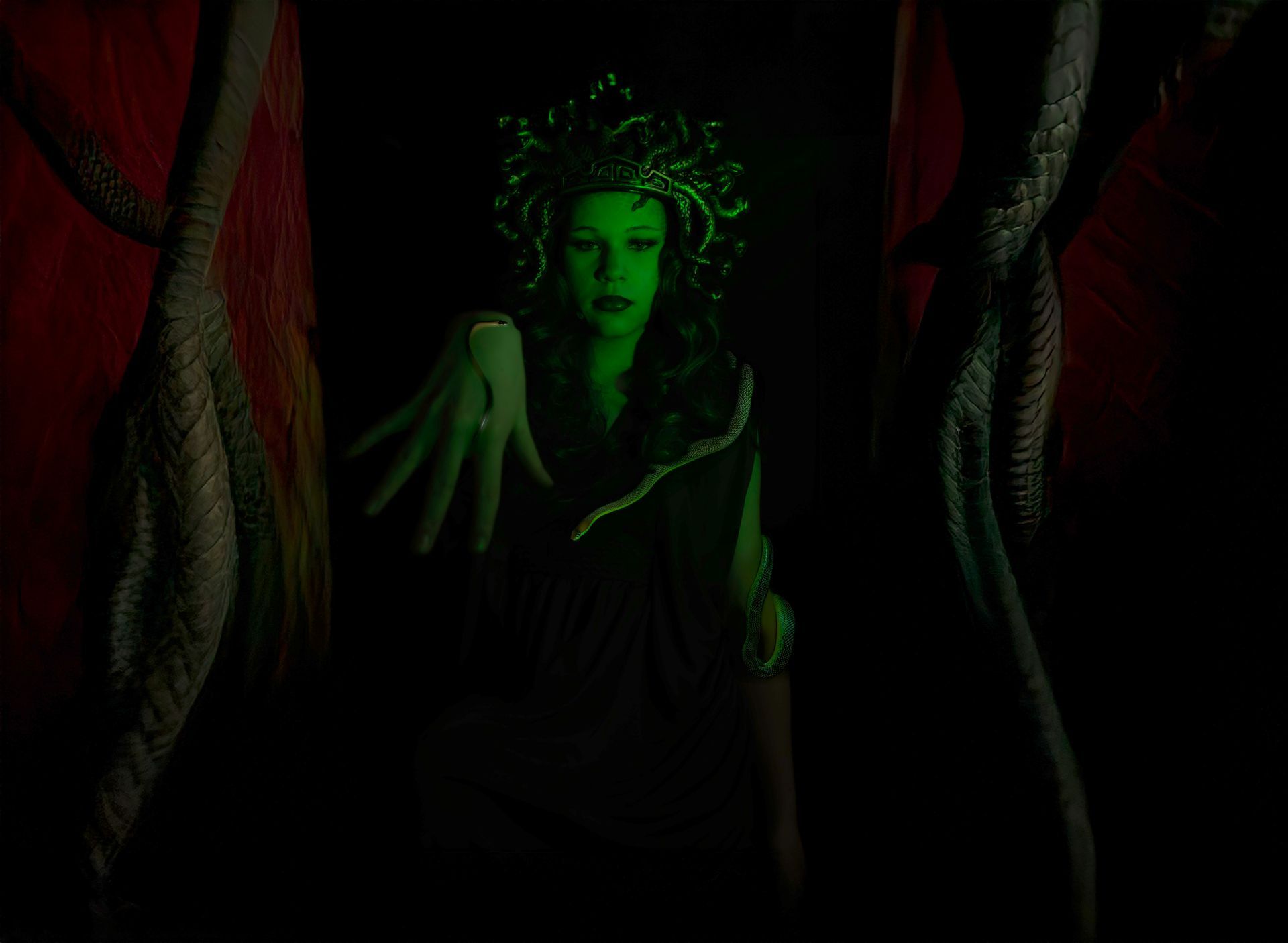 A woman in a medusa costume is glowing in the dark.