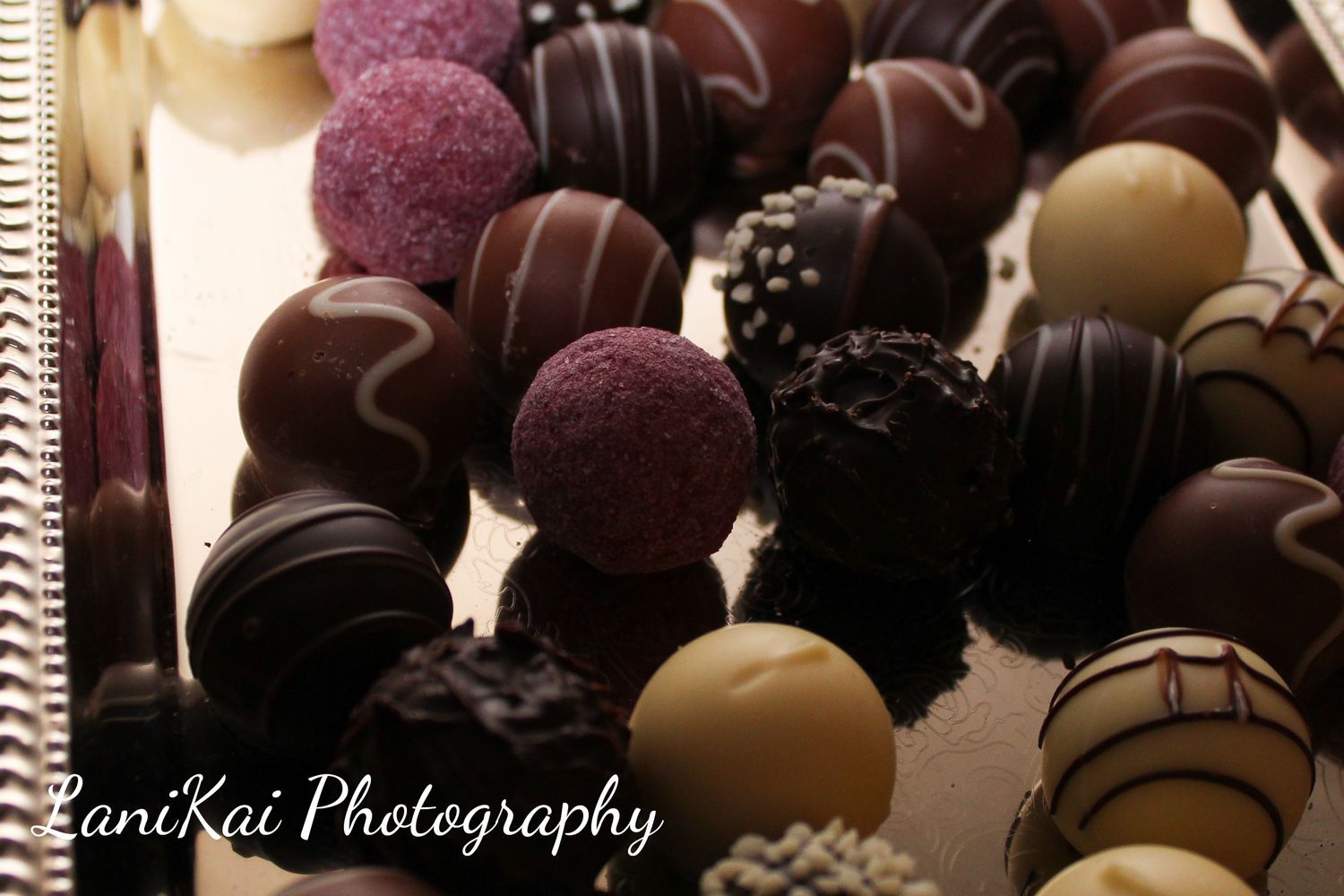A bunch of different colored chocolates with pani kai photography written on the bottom