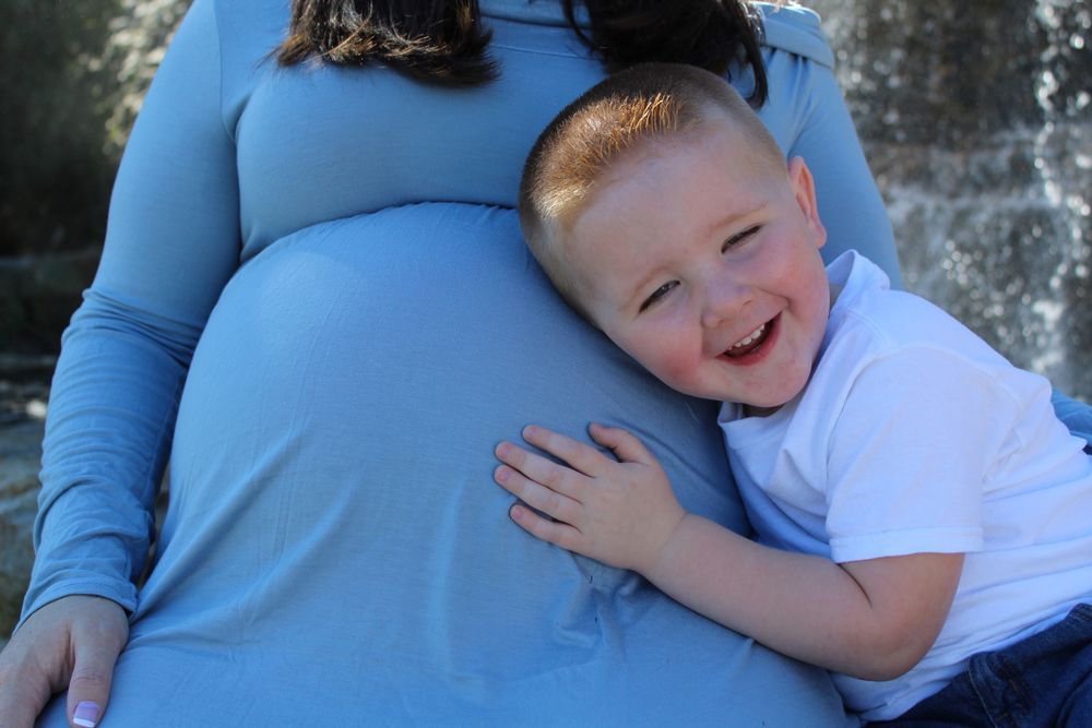 Little Kid Touching His Mother's Baby Bump