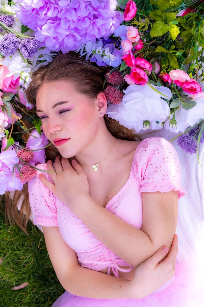 A teenager lying on the field of roses posing for a picture