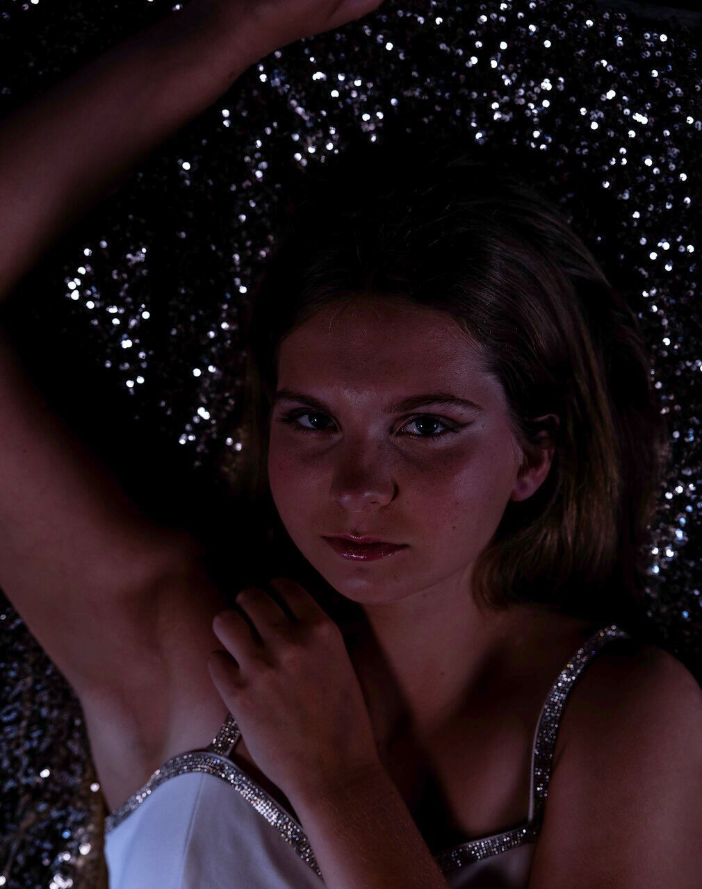 A woman in a white dress is posing for a picture