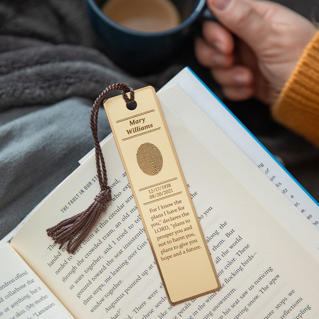 A person is reading a book with a bookmark that says happy birthday