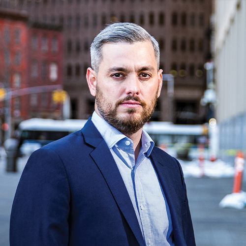 A woman wearing a green jacket is smiling for the camera