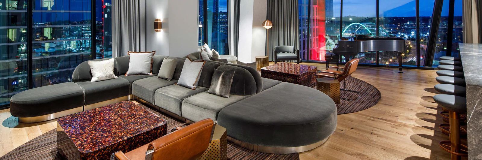 A living room with a couch , table , chairs and a piano.