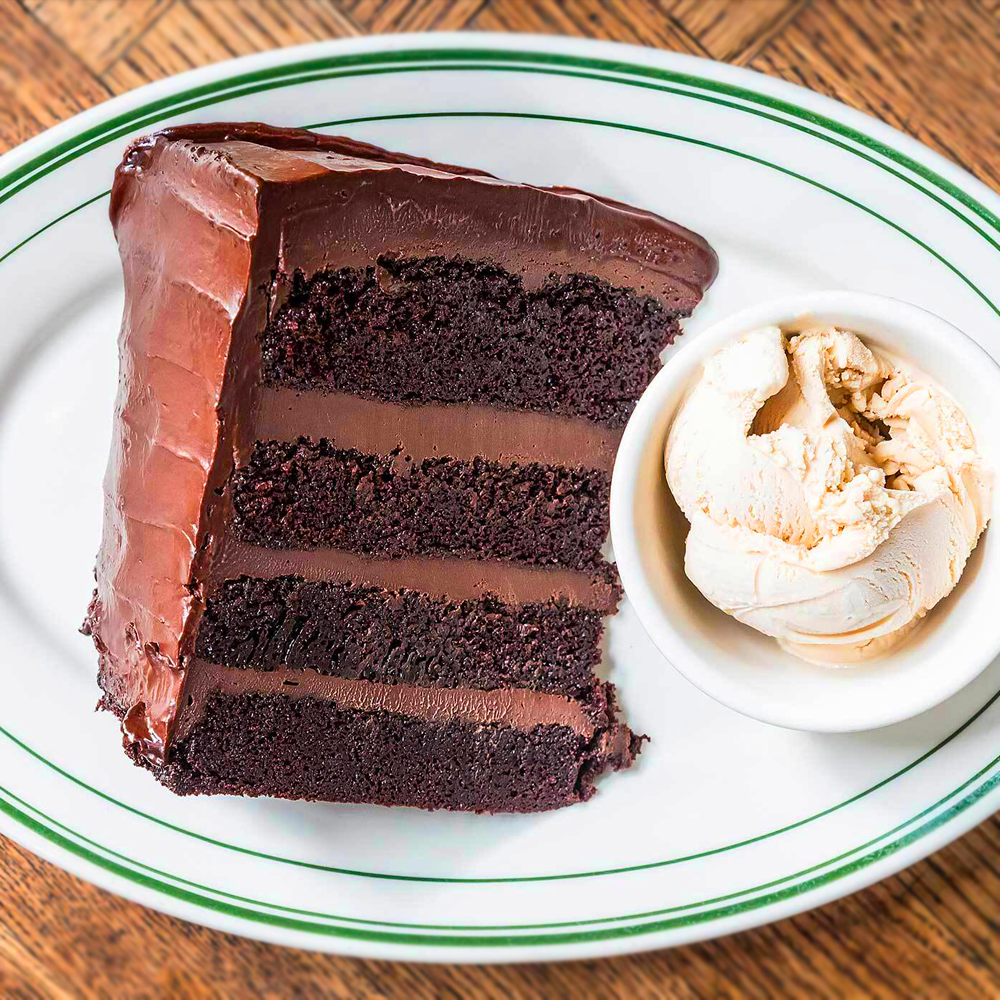A slice of chocolate cake next to a bowl of ice cream