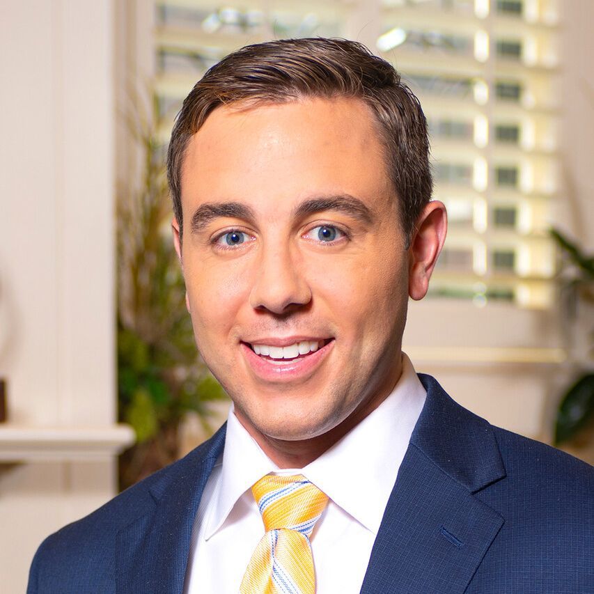 A man in a suit and tie is smiling for the camera.