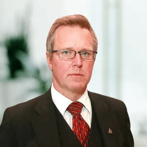 A man in a suit and tie is wearing glasses.