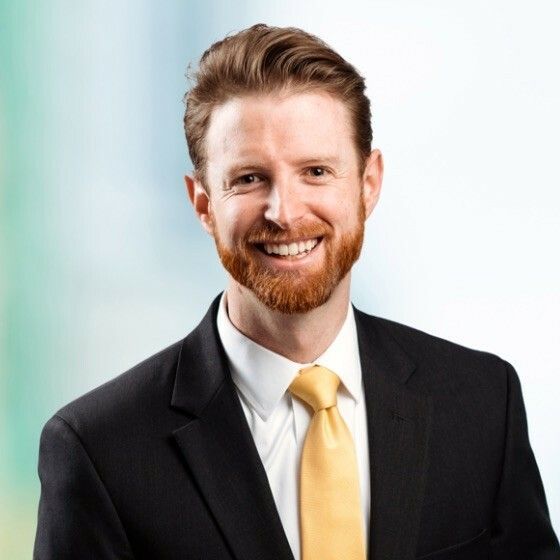 A man in a suit and tie is smiling for the camera