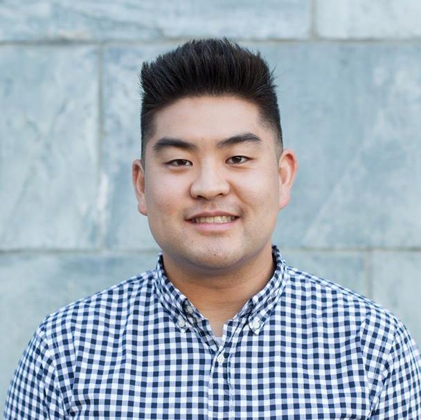 A man in a plaid shirt is smiling for the camera.