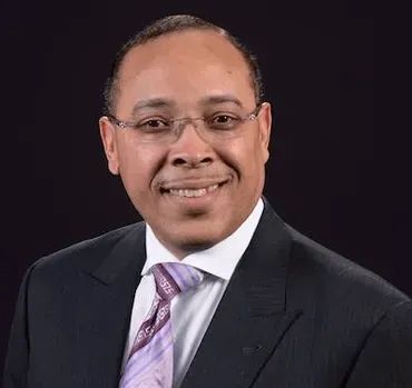 A man in a suit and tie is smiling for the camera.