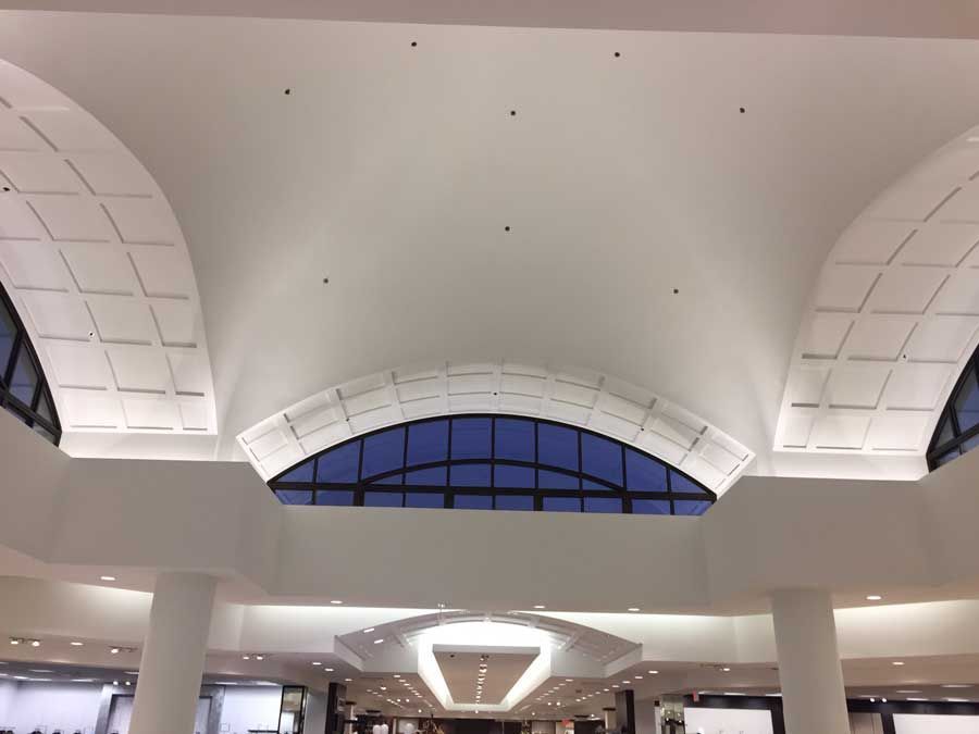 Looking up at the ceiling of a building with arched windows