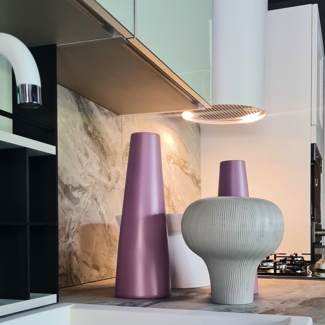 Una cucina con vasi viola e bianchi sul bancone