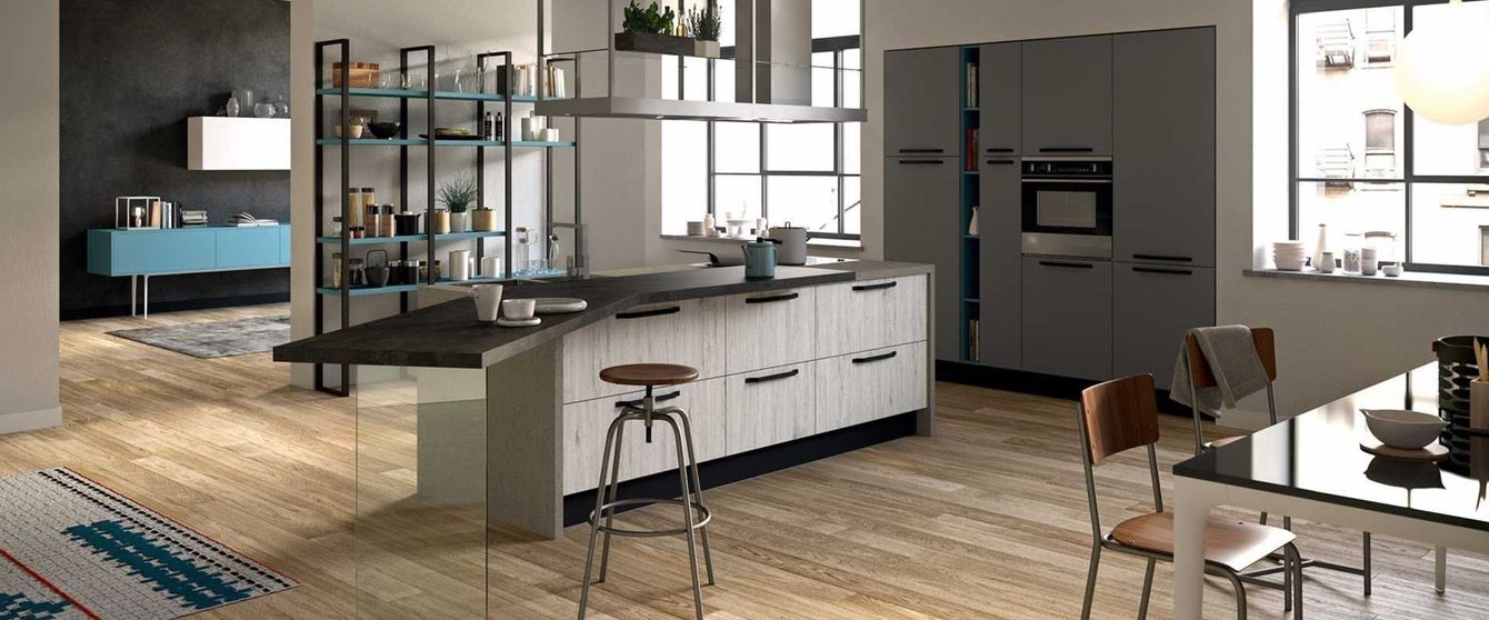 Una cucina con una grande isola al centro, un tavolo e delle sedie.