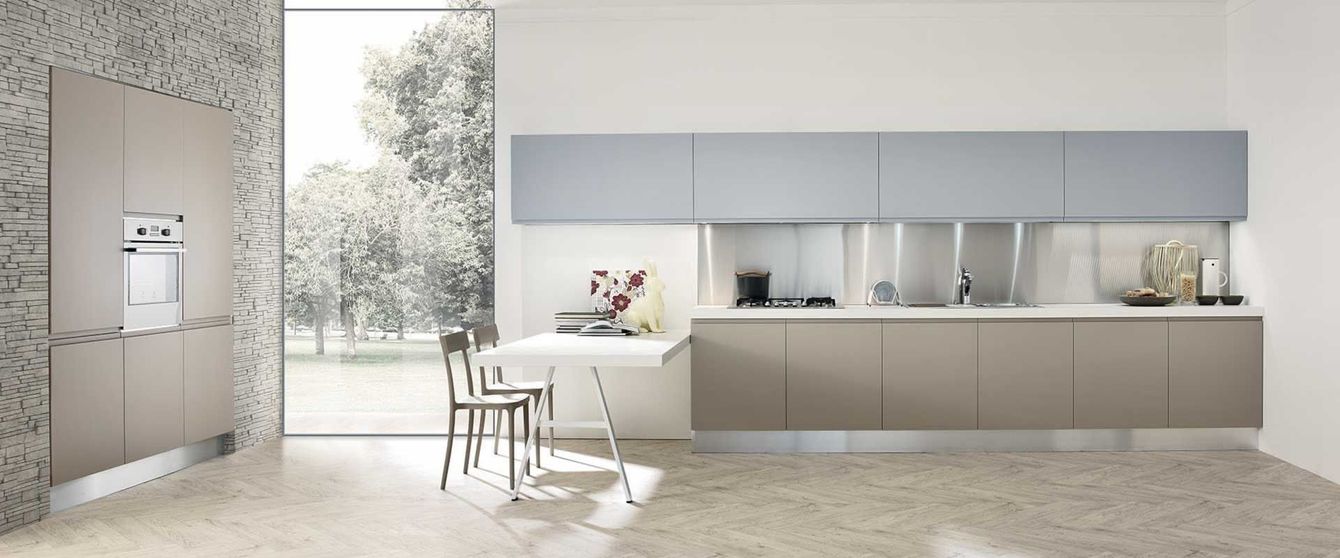 Una cucina con tavolo e sedie e una grande finestra