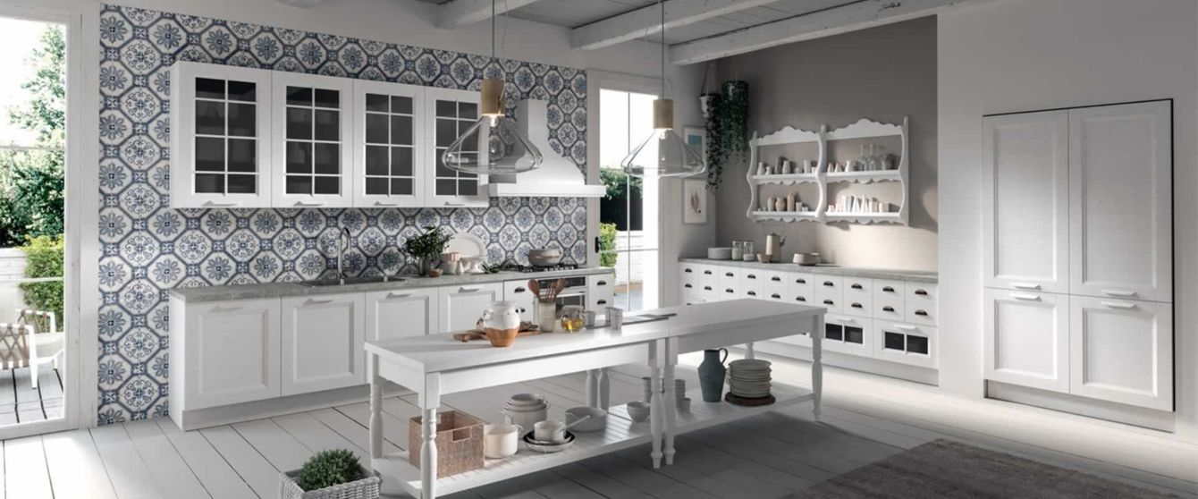 Una cucina con mobili bianchi e una grande isola al centro.